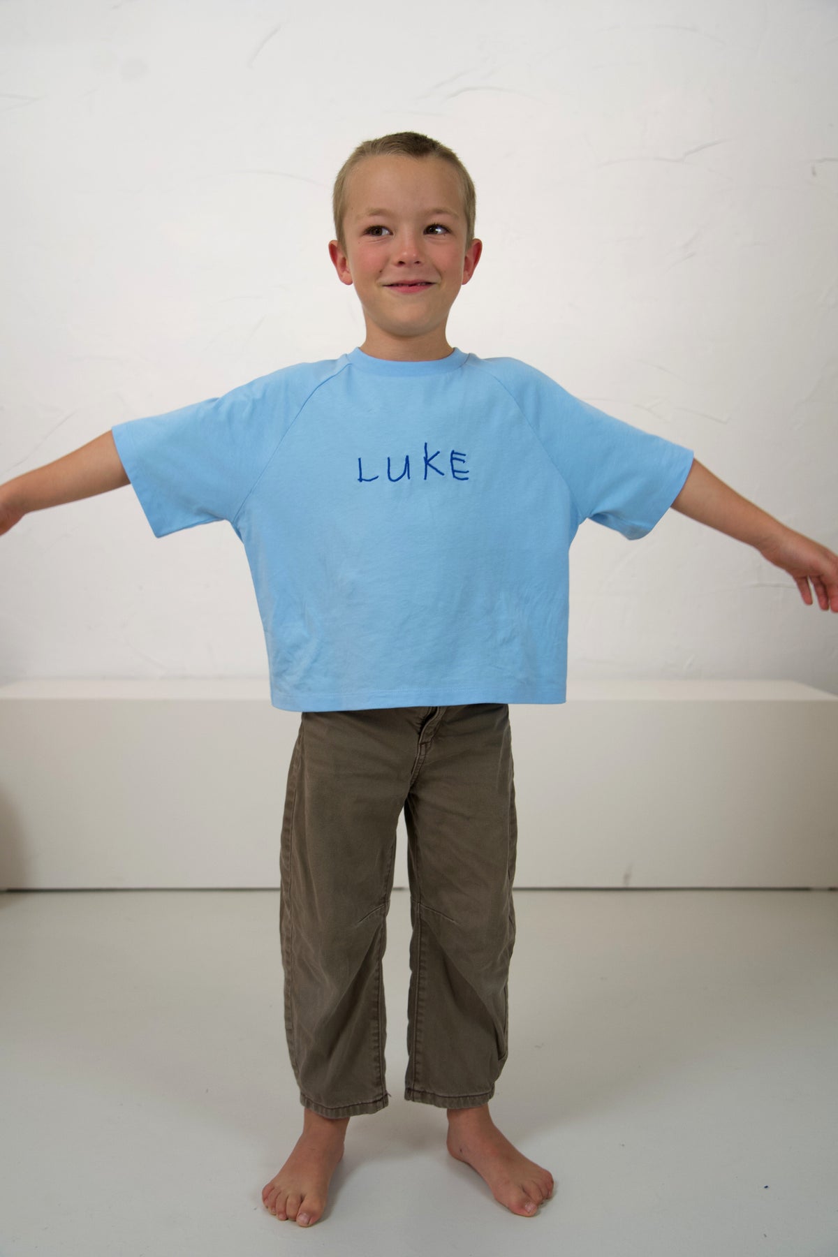 Child wearing the Blueberry Momenta kids tee, showing the relaxed fit and embroidered drawing.