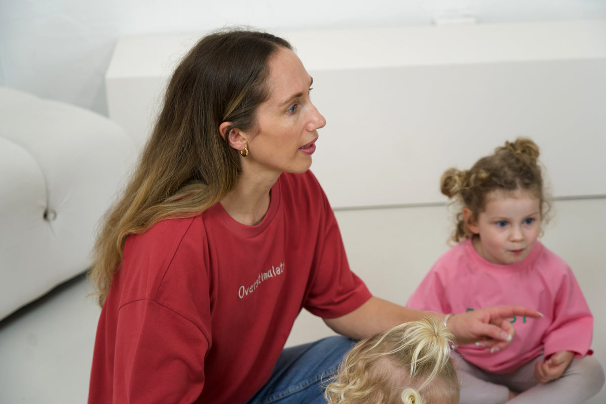 Adult wearing the Cabernet Momenta women’s tee with children at the Blanc Space studio shoot.