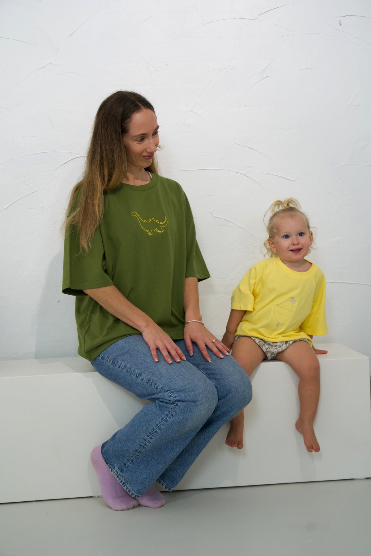 Adult wearing the Moss Momenta women’s tee beside a child in the Dandelion kids tee.
