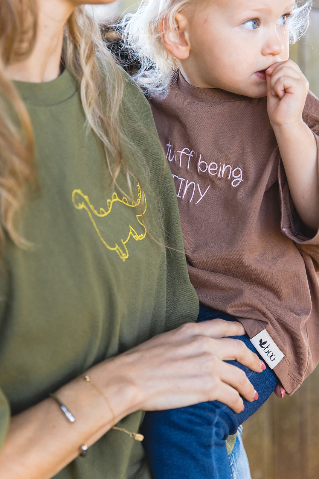 A close look at a drawing embroidered on a green everyday tee